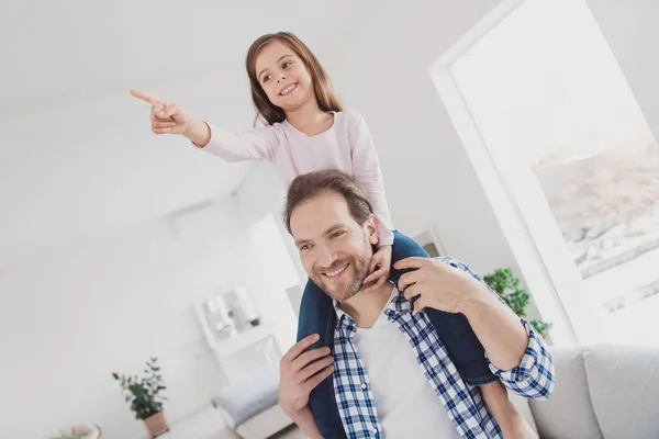 Portrait of his he her she nice cute lovely adorable attractive pre-teen cheerful cheery girl handsome bearded dad daddy having fun pointing far away dream in light white interior room indoors — Stock Photo, Image