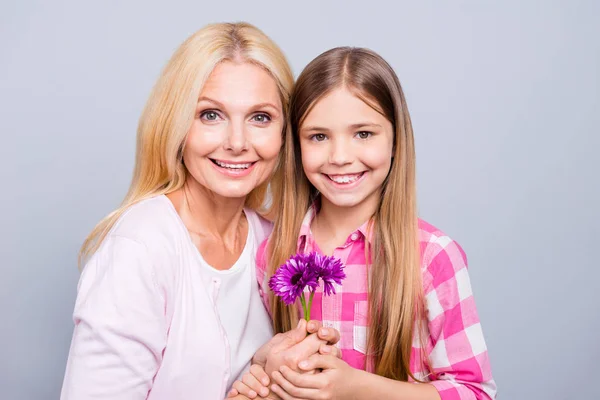 Close up photo two blond haired she her granny granddaughter little granddaughter weekend 8 March holiday unexpected flowers wear pink plaid checkered shirt sweater pullover isolated light grey background — стоковое фото