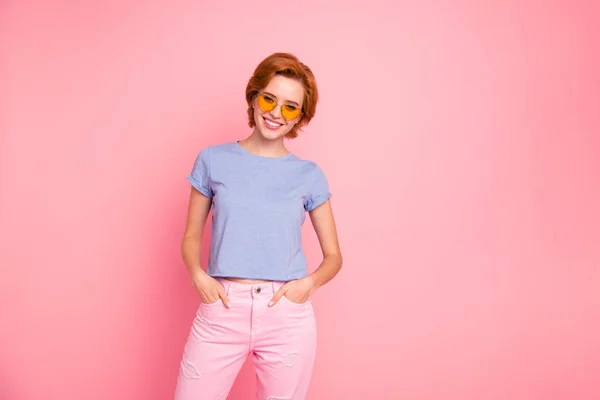 Retrato dela ela agradável bonito encantador atraente linda alegre menina alegre vestindo olhar casual legal óculos amarelos de mãos dadas em bolsos isolados sobre fundo pastel rosa — Fotografia de Stock