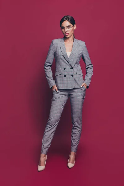 Vertical full length body size view portrait of her she nice-looking classy pretty attractive lady wearing gray checkered suit high heels isolated over maroon burgundy marsala pastel background — стоковое фото