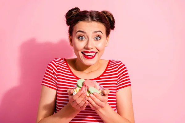 Gros plan portrait d'elle elle belle mignonne charmante séduisante brillance glamour belle fille gaie affamée en t-shirt rayé tenant dans les mains pile de délicieux snack coloré isolé sur fond rose — Photo