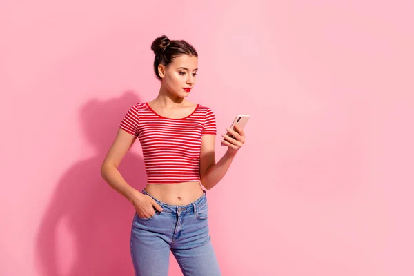 Portret van haar ze aardig leuke charmante aantrekkelijk mooie winsome ernstige meisje dragen gestreept t-shirt denim gadget apparaat geïsoleerd over roze pastel achtergrond in de hand te houden — Stockfoto