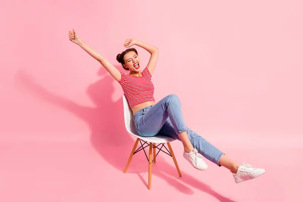 Fin söt glans attraktiva glamorösa winsome härliga glada glada flicka klädd i randig tshirt jeans liggande på stolen ha kul tid isolerat över rosa pastell bakgrund — Stockfoto