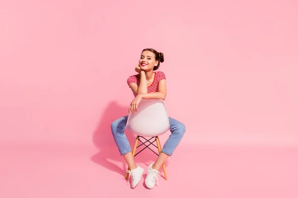 Nice-olhando atraente glamoroso magnífico lindo brilho alegre menina alegre vestindo jeans tshirt listrada sentado na cadeira ter tempo livre isolado sobre fundo pastel rosa — Fotografia de Stock