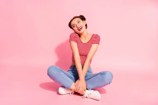 Ella ella agradable dulce atractivo glamoroso adorable encantador brillo alegre alegre optimista chica con pantalones vaqueros de camisetas a rayas sentado en el suelo aislado sobre el fondo de pastel rosa — Foto de Stock