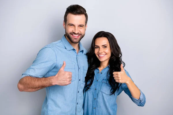 Close up portrait two beautiful amazing she her he him his couple lady guy stand close hold hands thumbs up recommend news wear casual jeans denim shirts outfit clothes isolated light grey background