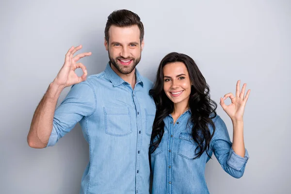 Close up portrait two amazing she he he he his couple lady guy couple stand close hold hands arms show okey symbol wear casual jeans denim shirts outfit clothes isolated light grey background —  Fotos de Stock