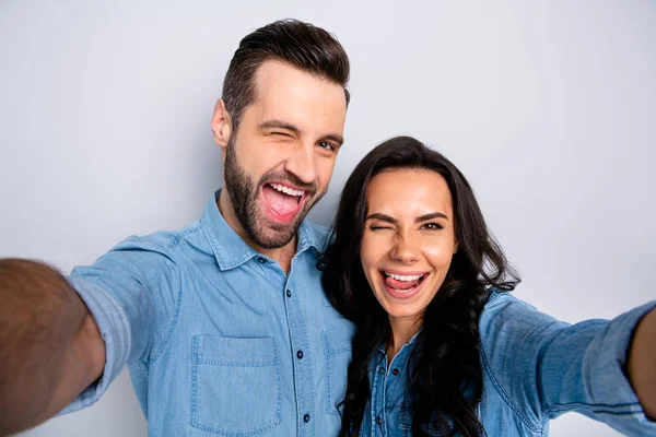 Close up retrato funky incrível ela ele ele ele seu casal senhora cara casal fazer tomar selfies piscar os olhos língua para fora boca desgaste casual jeans ganga camisas roupa isolado luz cinza fundo — Fotografia de Stock