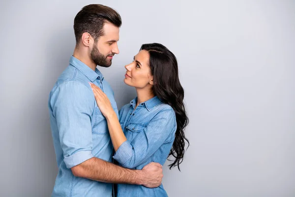 Perfil vista lateral foto de encantadores esposos ocasionales guapos cariñosos casados encantados vestidos con ropa de mezclilla azul aislados sobre fondo gris —  Fotos de Stock