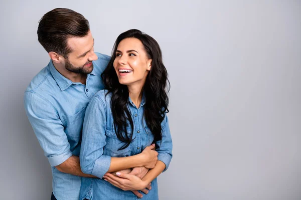 Verrückte Kerle. Porträt gut aussehender zufriedener unbeschwerter Bonding-Hipster Millennials lachender Narr, der sich zart behaglich kuschelt und blaue Jeanshemden auf silbernem Hintergrund trägt — Stockfoto