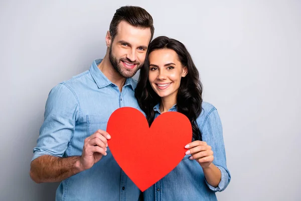 Papierkartenherz in riesiger Form. Porträt von süßen Bonding schönen Paar zeigt Valentinstag Feiertagsgeschenke präsentieren Zuneigung tragen lässige Jeansshirts isoliert auf aschgrau Hintergrund — Stockfoto