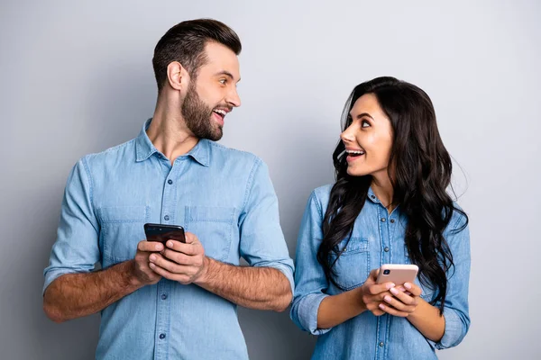 Close up foto incrível ela ele ele ele sua senhora cara telefone inteligente mãos braços ler leitor notícias olhar interesse olhos desgaste casual jeans jeans camisas roupa isolado luz cinza fundo — Fotografia de Stock