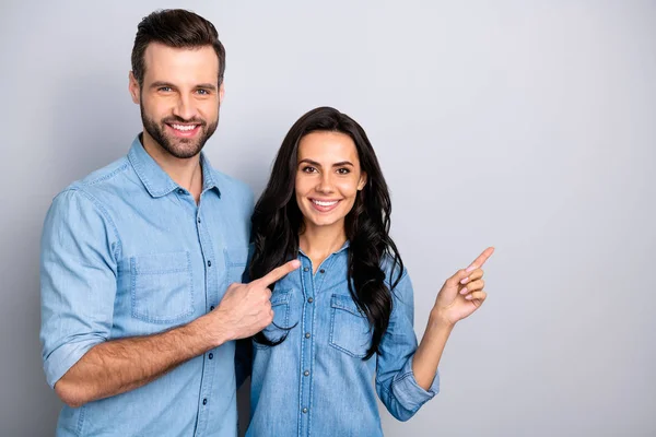 Close up photo amazing she her he him his couple lady guy hold hands fingers side empty space indicare direct news wear casual jeans denim shirts outfit clothes isolated light grey background — Foto Stock