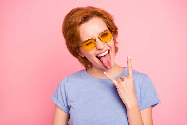 Retrato de ella ella agradable lindo encantador atractivo de moda alegre alegre loca chica usando casual azul camiseta gafas amarillas mostrando cuerno divertirse aislado sobre fondo rosa —  Fotos de Stock