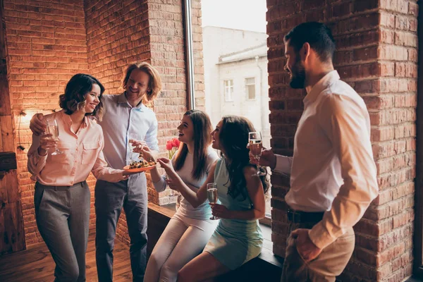 Company of nice attractive pretty classy cheerful positive guys ladies having fun talk romantic atmosphere every year tradition buffet snack in fashionable industrial loft interior room indoors — Stock Photo, Image