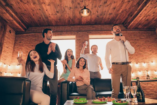 De cerca foto mejores amigos karaoke noche fin de semana vacaciones pasar el rato ella sus señoras él su solista vocal chicos ayudar a cantar aplaudir las manos brazos usar vestidos camisas formal usar sentarse sofá loft habitación interior — Foto de Stock