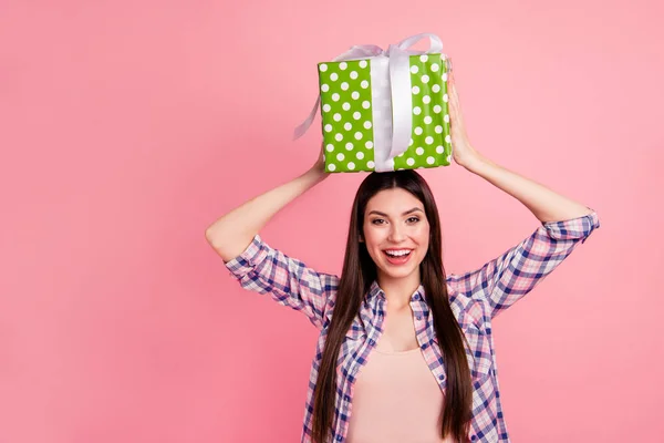 Retrato de agradável atraente bonito charmoso winsome encantador alegre alegre senhora de cabelos lisos vestindo camiseta verificada segurando as mãos na cabeça grande caixa verde grande isolado sobre fundo rosa — Fotografia de Stock