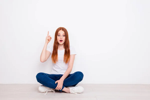 Full längd kropps storlek foto vacker hon hennes dam sitta golvet ben korsade begrunda fundersam ha aning finger upp glädje slitage casual t-shirt Jeans denim outfit kläder isolerad vit bakgrund — Stockfoto