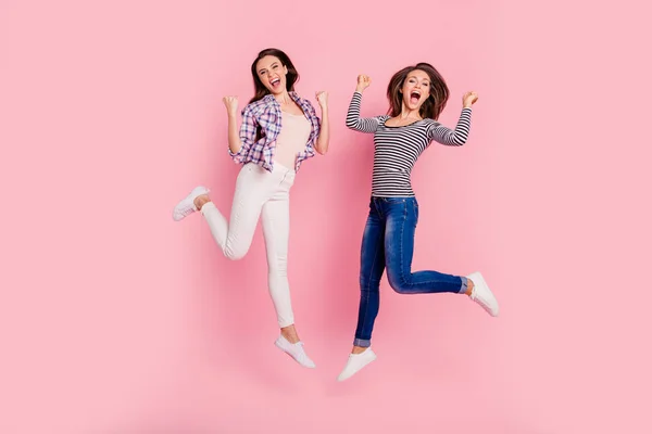 Longitud completa tamaño del cuerpo ver foto de señoras infantiles juguetonas descuidadas engañando aislados divertidos hipsters funky usando camisetas vaqueros sobre fondo de color rosa —  Fotos de Stock