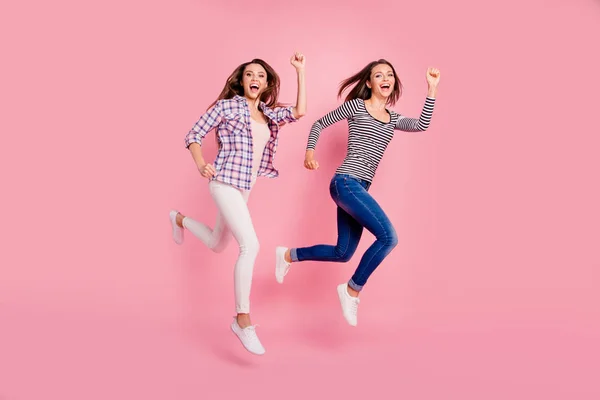 Ganzkörpergröße Ansicht Foto von aktiven energischen aufgeregten Damen lustig genießen funky lachen Lachen mit Spaziergängen in modernen Hemden Jeanshosen isoliert auf rosafarbenem Hintergrund gekleidet — Stockfoto