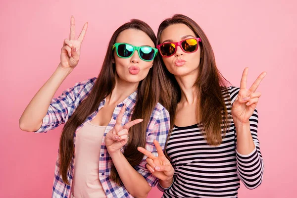 Portrait de cool magnifiques dames étudiants coquettish attirer les garçons portant des lunettes de vue faisant v-signes ayant week-end repos se détendre habillé de chemises colorées isolées sur fond rose — Photo