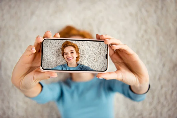 Close up photo amazing beautiful she her lady hands telephone make take selfies toothy smile adorable vacation days wear blue pullover clothes lying carpet floor divan house loft living room indoors — Stock Photo, Image