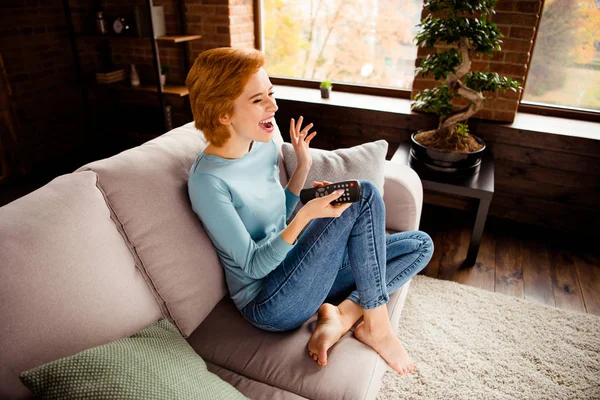 Close up side profile photo beautiful she her lady hands arms tv console changing channels find favorite comic serial wear blue casual pullover jeans denim sit comfy divan house living room indoors