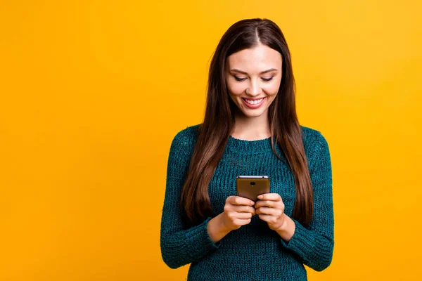 Tutup foto yang indah dia wanita memegang tangan telepon coba periksa baru bermain game chatting teman-teman memakai hijau rajutan pullover jumper terisolasi kuning latar belakang — Stok Foto