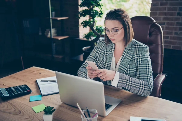 Zavřít fotografii Rozšafín Ctibum ona její obchodní dáma podržet telefon Smart telefon Hledat zkontrolovat email dopis SMS zpráva notebook stůl sedět kancelářský křeslo nosit technické údaje formální — Stock fotografie