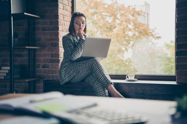 Close up photo busy she her business lady concentrata ponderazione pensieroso contemplazione bevanda calda guardare tenere fermo notebook sedersi finestra davanzale ufficio usura specifiche tacchi alti formalwear a scacchi plaid suit — Foto Stock