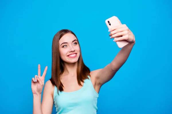 Close up photo beautiful amazing she her lady toothy hold hands arms phone make take selfies show v-sign say hi instagram followers wear casual tank top outfit clothes isolated blue background — Foto de Stock