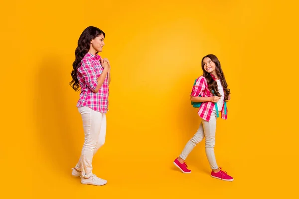 De cerca foto de perfil lateral hermosa ella sus modelos damas mamá hija pequeña tiempo de estudio de despedida nos vemos pronto ver movimiento de distancia llevar casual rosa cuadros camisas aisladas fondo amarillo —  Fotos de Stock