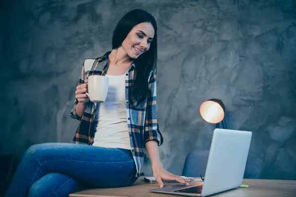 Retrato de agradável bonito atraente encantador alegre morena senhora vestindo camiseta verificada tempo livre navegação notícias vídeo chat sentado na mesa no estilo loft industrial interior local de trabalho estação — Fotografia de Stock