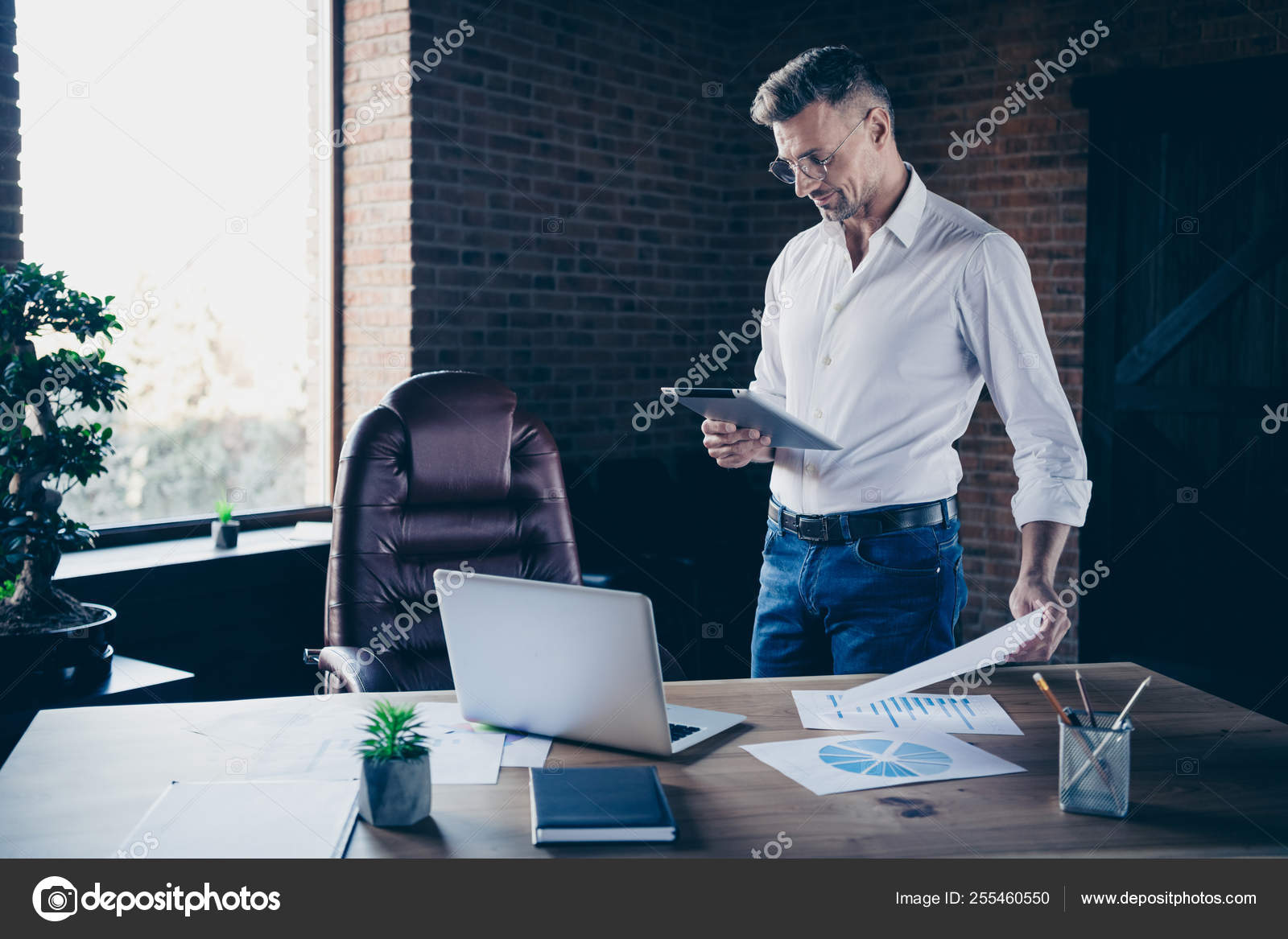 Close Side Profile Up Photo Handsome He Him His Macho Guy Ponder Pensive Attentive Look E Book E Reader Watch Webinar Check Numbers Notebook Table Stand Office Wear Specs Formal Wear White Shirt Stock