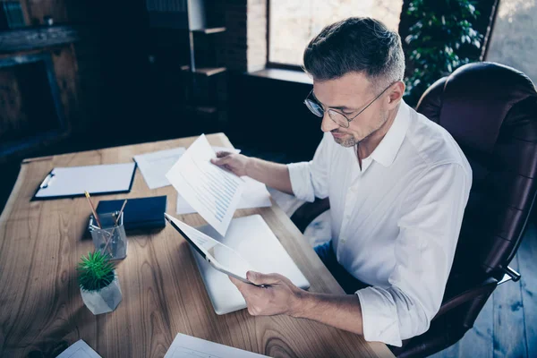 Nahseite Profil nach oben Foto gut aussehend er ihm seinen Macho Kerl grübeln nachdenklich aufmerksamen Blick E-Book E-Reader Uhr Webinar Prüfnummern Notebook Tisch sitzen Bürostuhl tragen Spezifikationen formale tragen weißes Hemd — Stockfoto