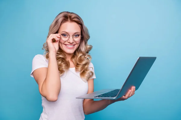 Ritratto di lei bella bella attraente attraente allegra signora dai capelli ondulati allegro in casual t-shirt bianca tenendo in mano computer portatile isolato su sfondo blu pastello — Foto Stock