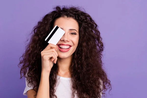 Close-up portrait of nice cute attractive lovely cheerful funny wavy-haired lady holding in hand new card wireless purchase closing one eye isolated on bright vivid shine violet pastel background — 图库照片