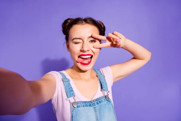 Close up foto bonita incrível ela sua senhora dois pães fazer tirar selfies mostrar v-sinal símbolo perto de olho língua para fora boca desgaste casual t-shirt jeans ganga macacão roupas isolado roxo violeta fundo — Fotografia de Stock