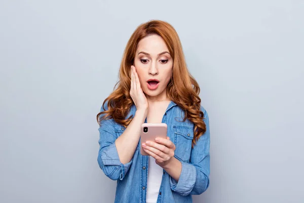 Close up photo beautiful she her her curly foxy lady arm hand phone reader news check instagram followers pictures unexpected unbelievable wear casual blue jeans denim shirt isolated grey background —  Fotos de Stock