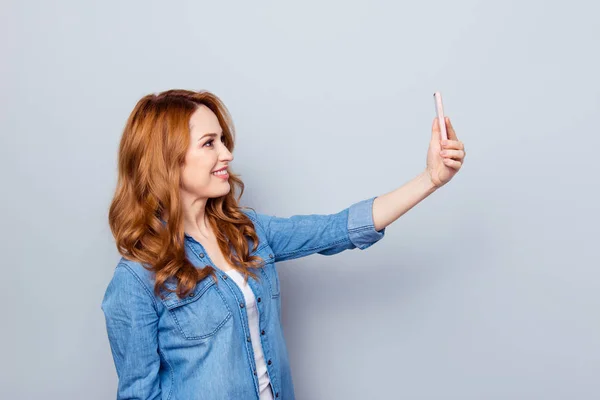 Close up side profile photo beautiful amazing she her curly lady hold hand telephone smart phone make take selfies tell speak skype wear casual blue jeans denim shirt isolated grey background — стоковое фото