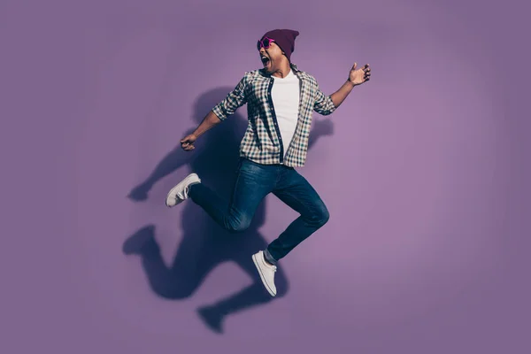 Tamaño completo cuerpo lado perfil foto de alegre guapo gritando en jeans vaqueros ropa moderna estrella gafas millennial aislado violeta fondo — Foto de Stock