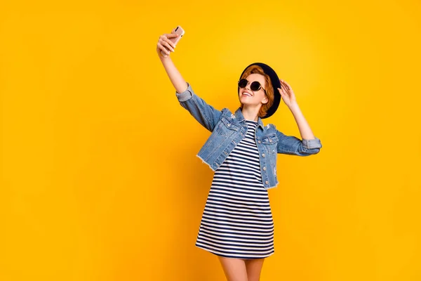 Close up photo beautiful foxy she her lady chic traveler modern look telephone make take selfies wear specs vintage hat casual striped t-shirt dress jeans denim isolated yellow bright background — Stock Photo, Image