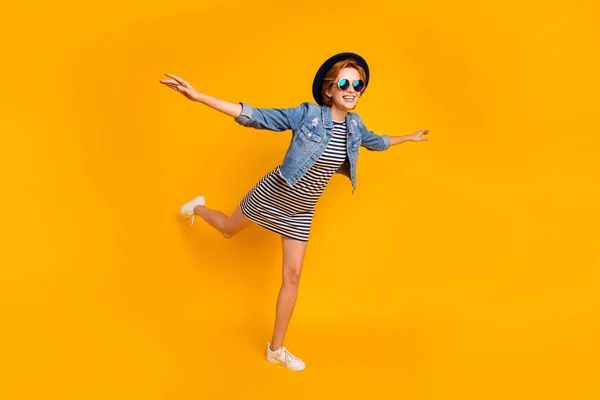 Full length body size view portrait of nice pretty lovely charming attractive cheerful optimistic girl flying on air like plane free time isolated over bright vivid shine yellow background — стоковое фото