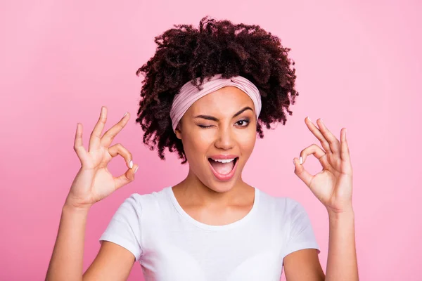 Close up photo beautiful amazing she her dark skin lady winking eye hold hand arm okey symbol toothy approved advising news wear head scarf casual white t-shirt isolated pink bright vibrant background — Foto de Stock