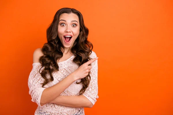 Retrato de agradable atractivo hermosa hermosa alegre alegre alegre dama de pelo ondulado en blusa transparente señalando a un lado copia vacío espacio en blanco aislado sobre brillante brillante brillo fondo naranja —  Fotos de Stock