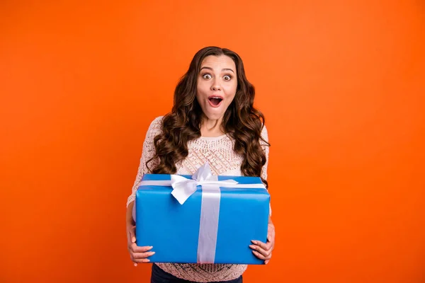 Retrato dela ela agradável-olhando atraente encantador feminino winsome alegre alegre menina de cabelos ondulados segurando em mãos grande caixa azul isolado no brilhante brilho vívido fundo laranja — Fotografia de Stock