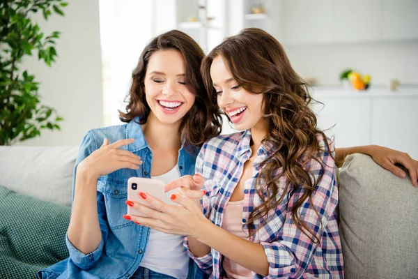 Närbild foto vacker hon hennes damer kamrater kompisar skratt telefon händer armar Visa skärmen funky skämt bild slitage Casual Jeans denim rutig pläd skjortor lägenheter sitta Divansoffa inomhus — Stockfoto