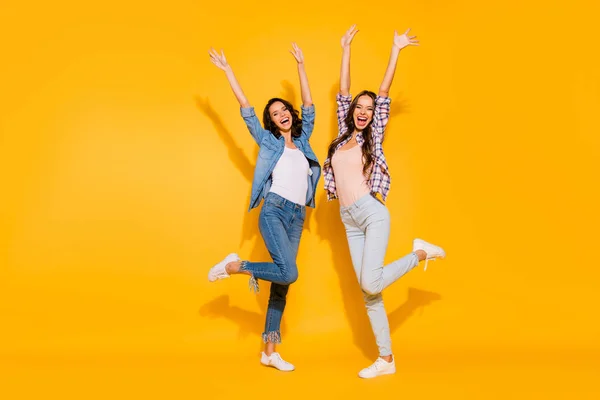 Full length body size view photo funny funky ladies youngsters raise hands arms wear plaid denim clothes sneakers travel scream shout free time weekends isolated on yellow background — Stock Photo, Image