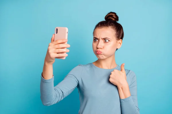 Close-up portrait of her she nice attractive lovely crazy childish girl holding in hand cell making selfie showing thumbup isolated over bright vivid shine turquoise background — Stock Photo, Image