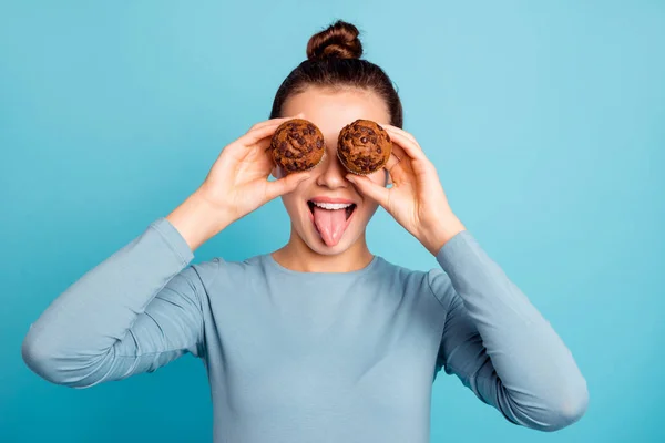 De cerca foto hermosa que su señora ocultar ojos aconsejando comprar comprador probar nuevo delicioso acaba de hornear sabrosos muffins de color cacao lengua hacia fuera boca usar jersey de suéter casual aislado azul brillante fondo —  Fotos de Stock